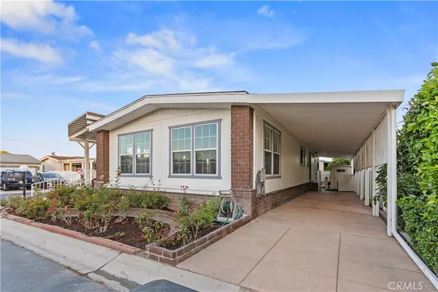 a view of a house with a small yard and potted plants