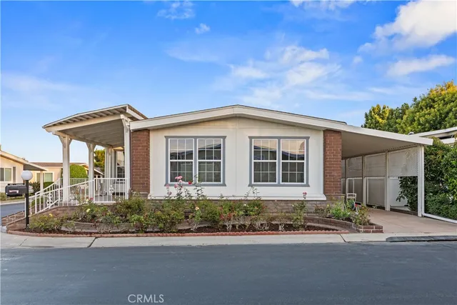 a tall white house with lots of trees in it