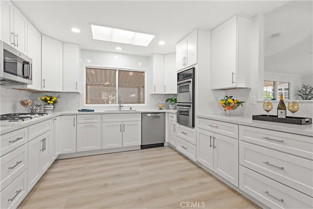a kitchen with granite countertop cabinets stainless steel appliances and a sink