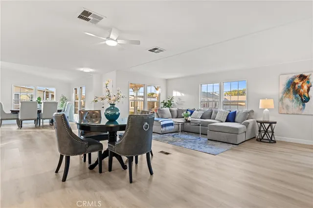 a view of a dining room and livingroom with furniture wooden floor a rug a fireplace