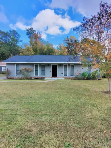a front view of house with yard and trees around