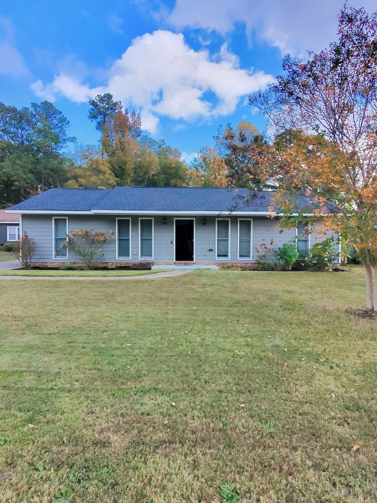 a front view of house with yard and trees around