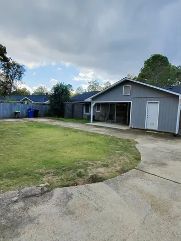 a view of a house with backyard and trees