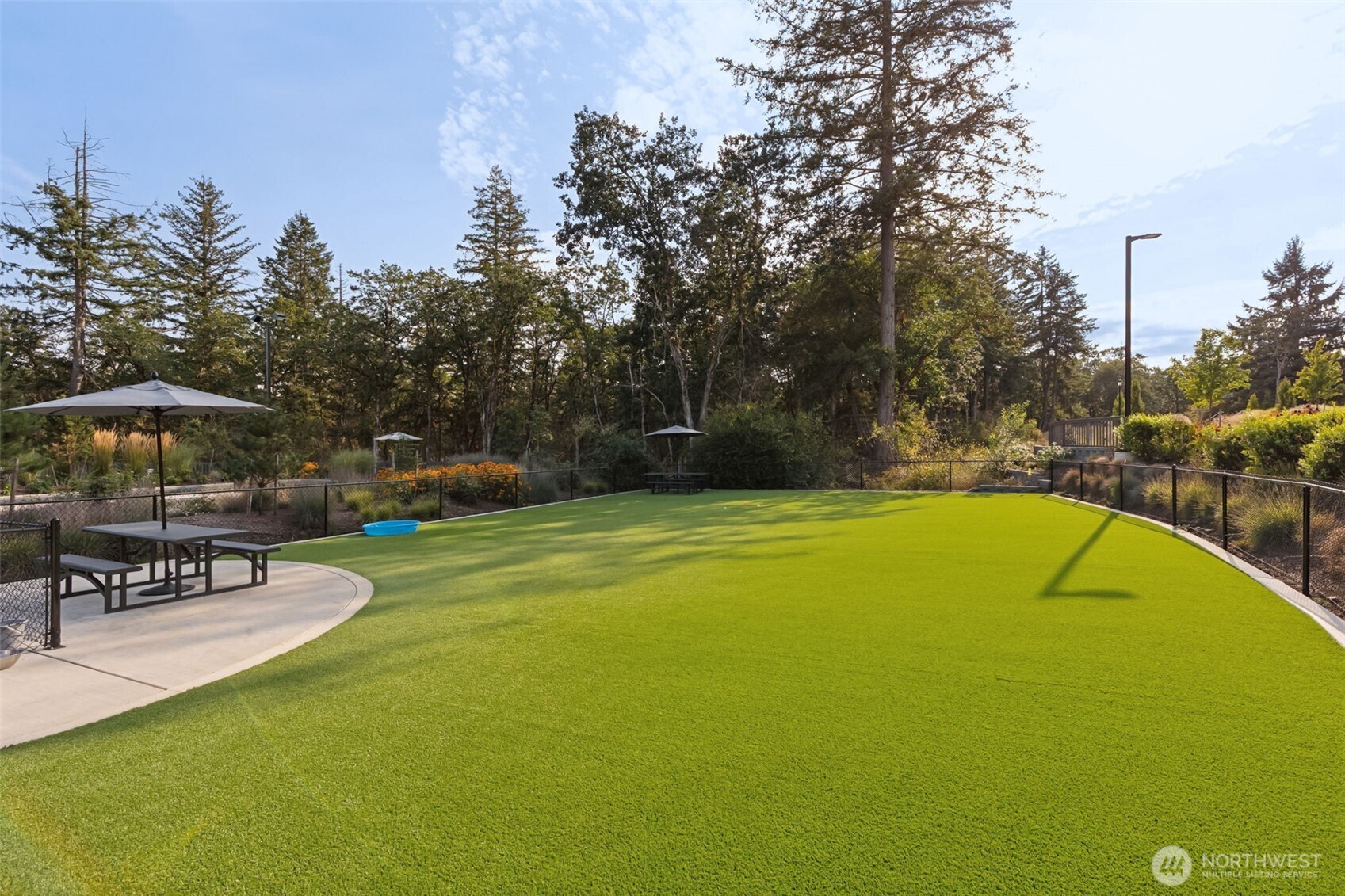 3111 Arrowroot Loop Southeast Olympia, WA 98513 - Photo 32 of 34 a view of a swimming pool with a table and chairs under an umbrella