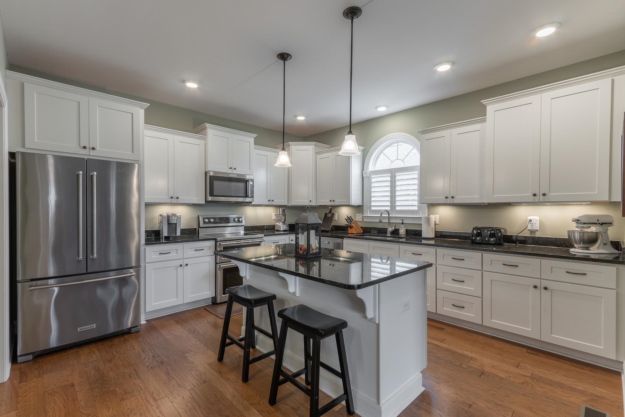 1685 Bald Eagle Circle Harrisonburg, VA 22801 - Photo 18 of 53 a kitchen with stainless steel appliances granite countertop a refrigerator a sink dishwasher a stove and white cabinets with wooden floor