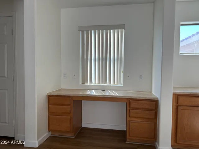 an empty room with window and chandelier fan