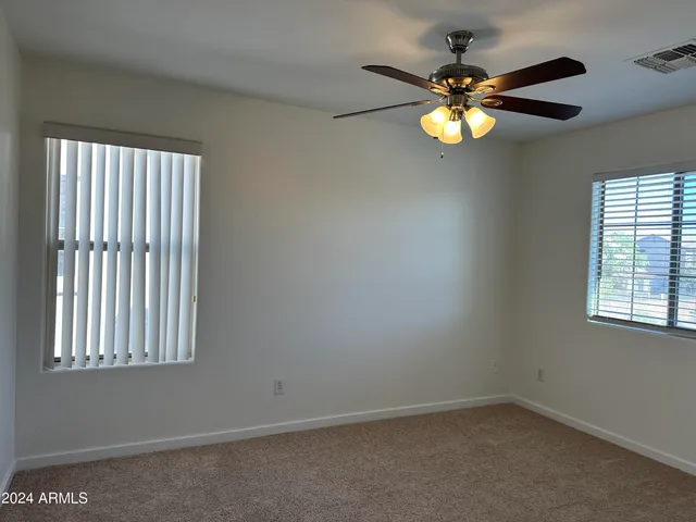 an empty room with a window and a fan