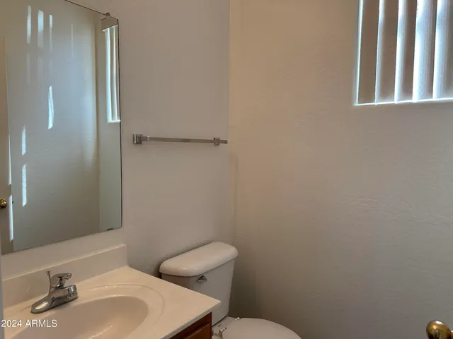 a bathroom with a sink mirror and toilet