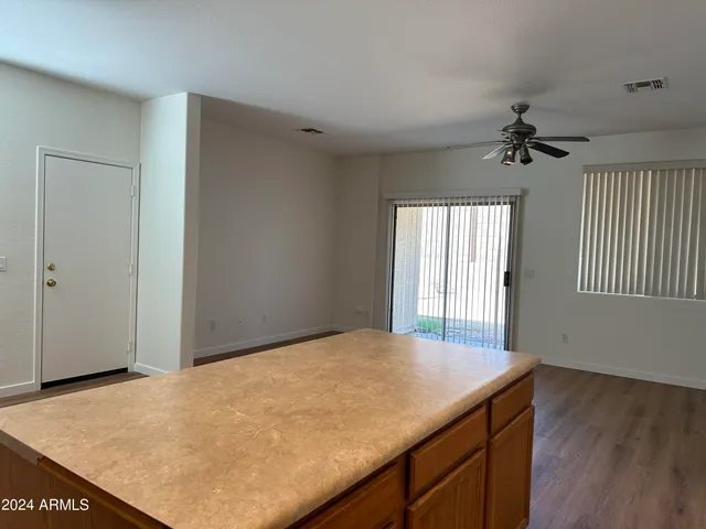 a view of a livingroom with a kitchen and a ceiling fan