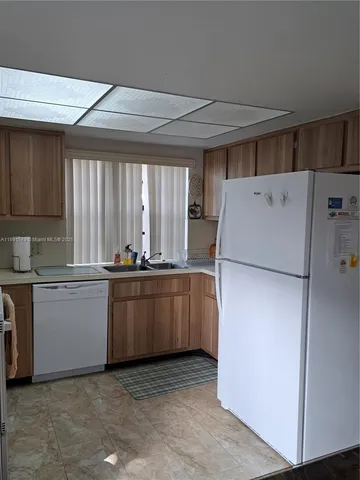 a kitchen with a refrigerator sink and stove