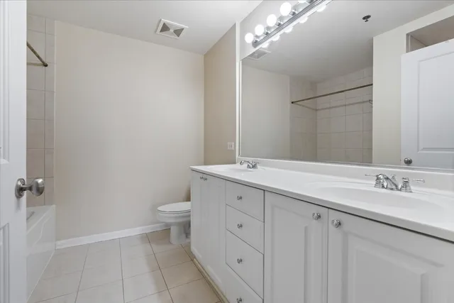 a bathroom with a double vanity sink and a toilet