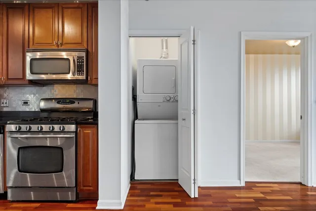 a kitchen with granite countertop stainless steel appliances a stove and a microwave
