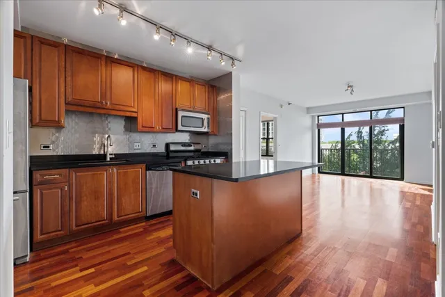 a kitchen with stainless steel appliances granite countertop a stove a sink and a refrigerator