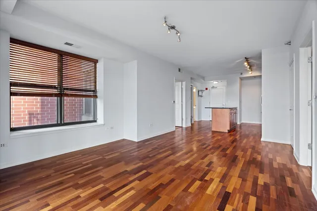 a view of empty room with wooden floor and windows