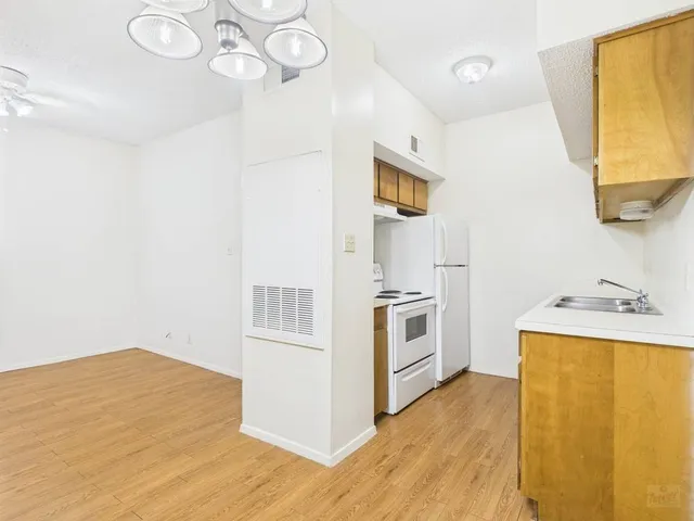 a kitchen with a sink cabinets stainless steel appliances and a window