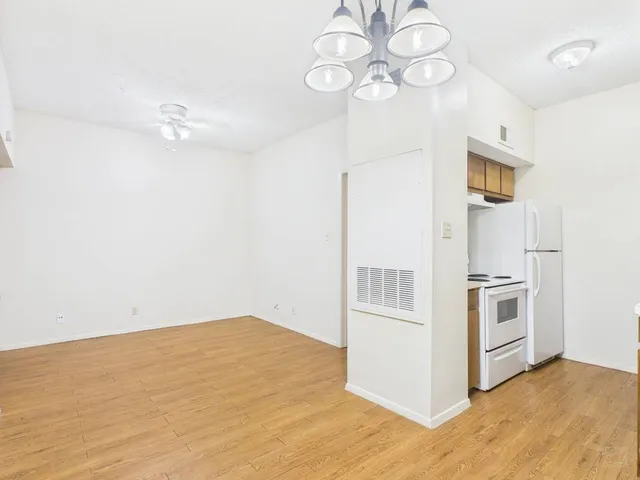 a view of a kitchen with wooden cabinet and stainless steel appliances