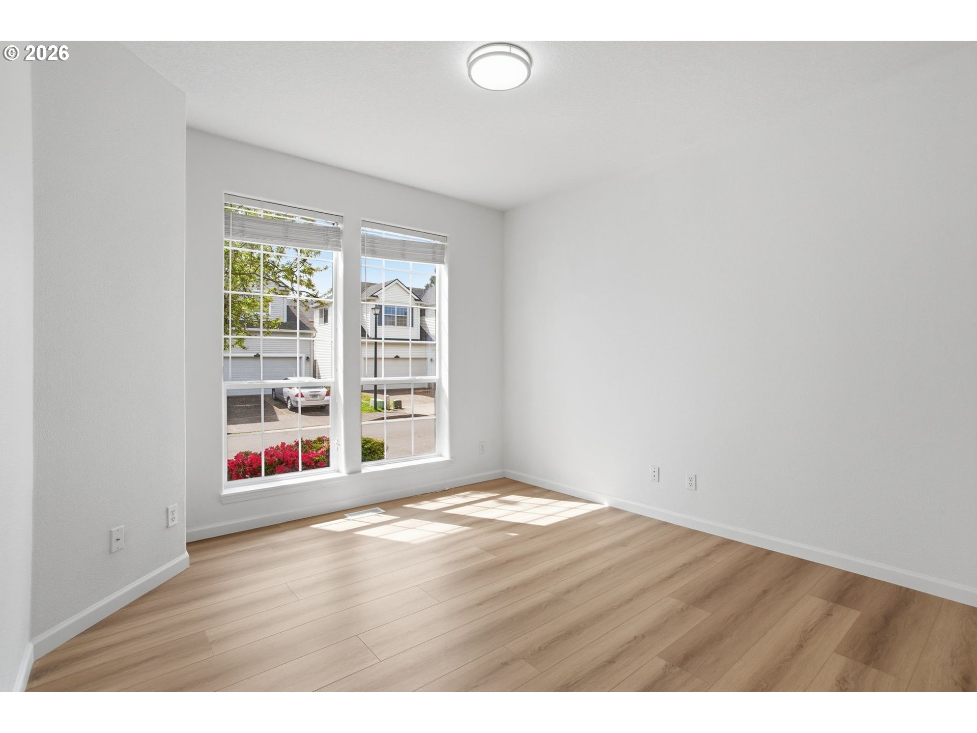 8911 Southwest Gravenstein Lane Tigard, OR 97224 - Photo 18 of 33 a view of an empty room with wooden floor and a window