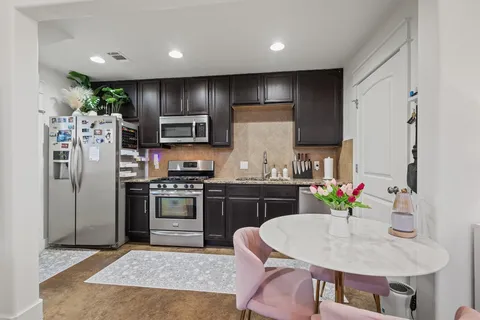 a kitchen with stainless steel appliances granite countertop a sink stove and refrigerator