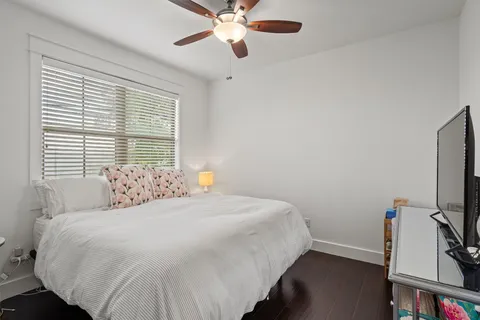 a bedroom with a bed and a flat tv screen on a dresser
