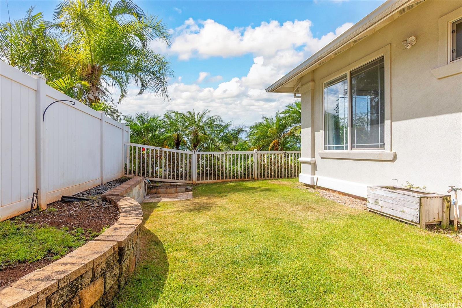 92-1087 Palahia Street, Unit B Kapolei, HI 96707 - Photo 21 of 24 a view of a backyard with a garden and tree