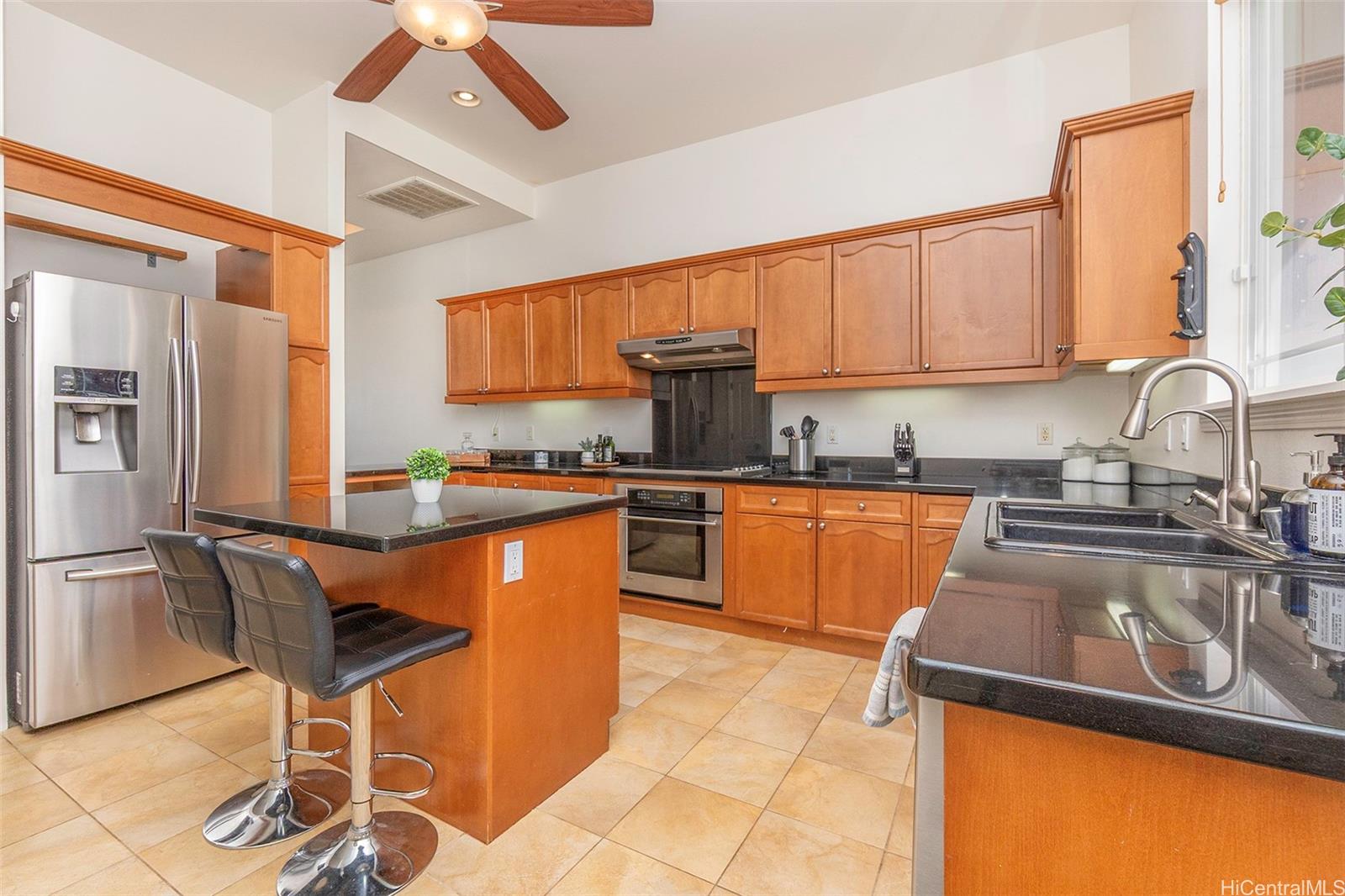 92-1087 Palahia Street, Unit B Kapolei, HI 96707 - Photo 5 of 24 a kitchen with granite countertop a sink stove and refrigerator