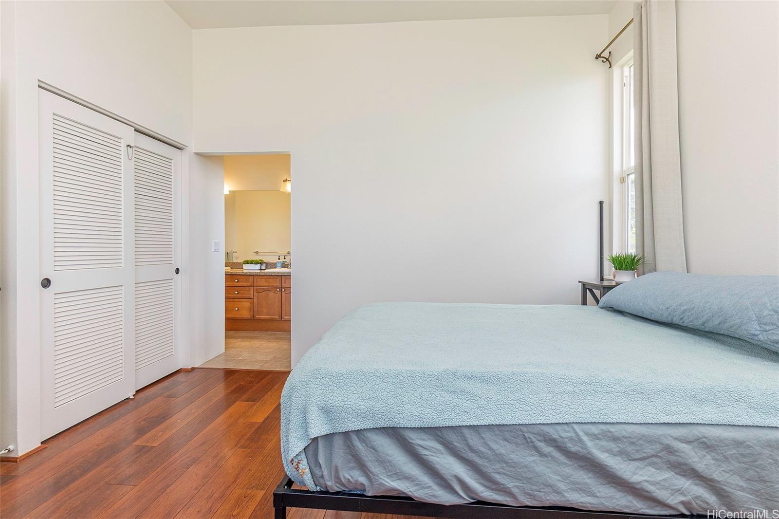 92-1087 Palahia Street, Unit B Kapolei, HI 96707 - Photo 7 of 24 a bedroom with a bed and wooden floor