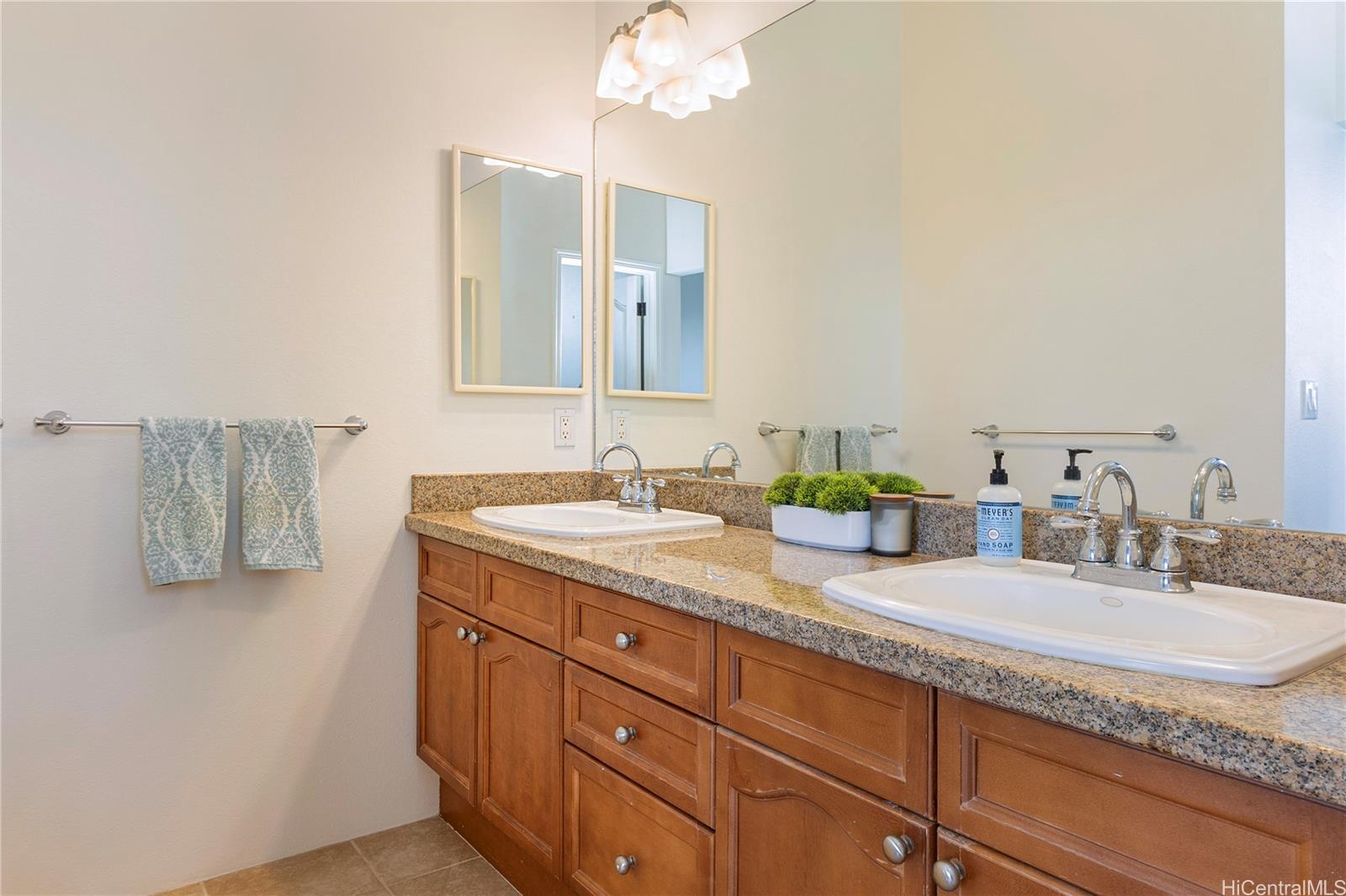 92-1087 Palahia Street, Unit B Kapolei, HI 96707 - Photo 8 of 24 a bathroom with a granite countertop double vanity and a mirror