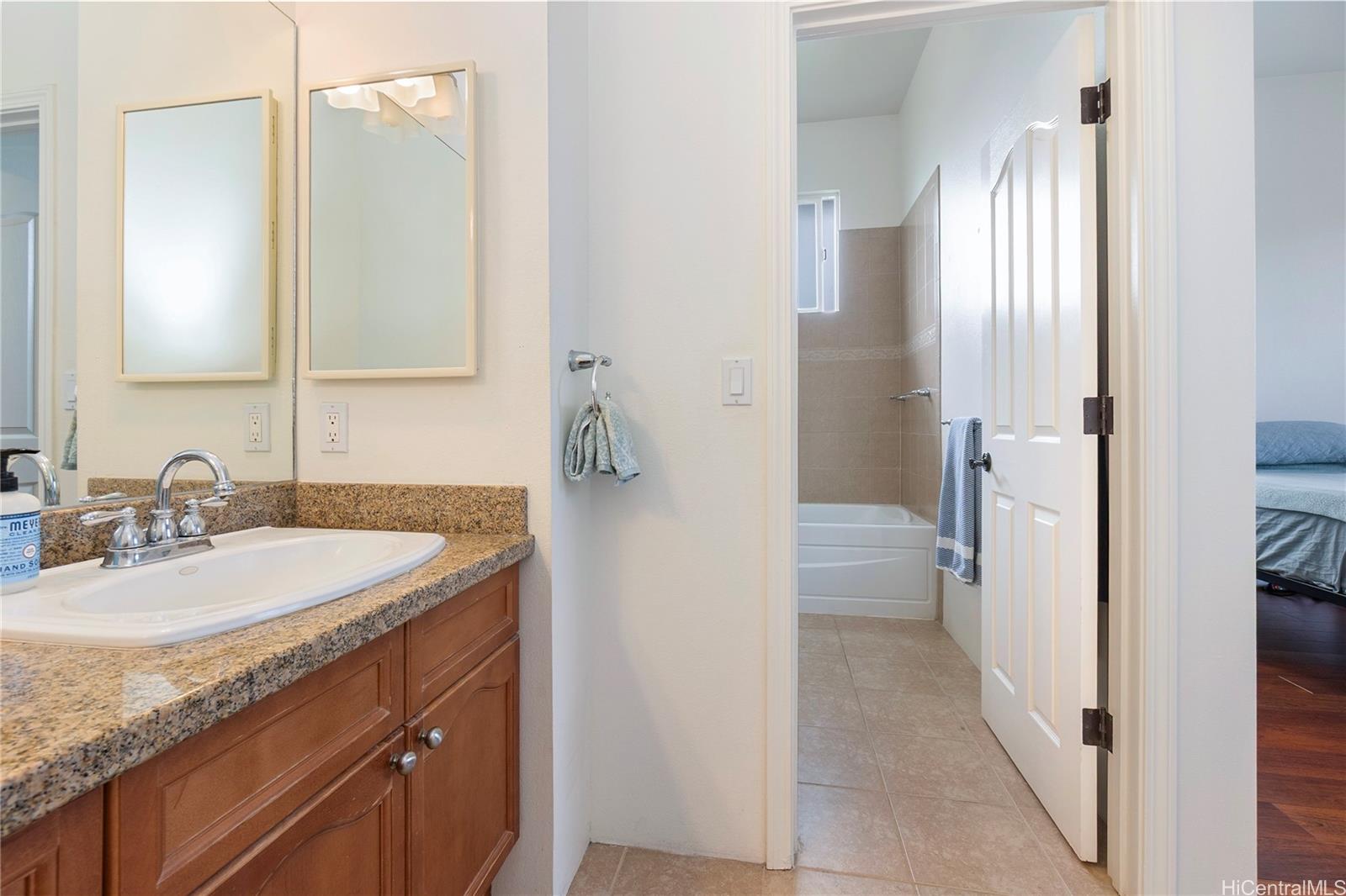 92-1087 Palahia Street, Unit B Kapolei, HI 96707 - Photo 9 of 24 a bathroom with a granite countertop sink and a mirror