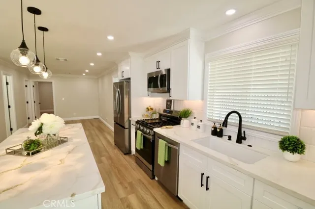a kitchen with stainless steel appliances a stove microwave and a sink