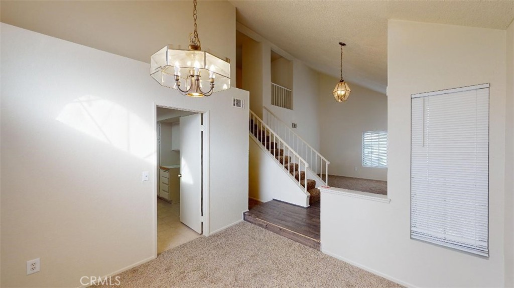 12246 Pluto Drive Victorville, CA 92392 - Photo 12 of 64 a view of a hallway with wooden floor and staircase