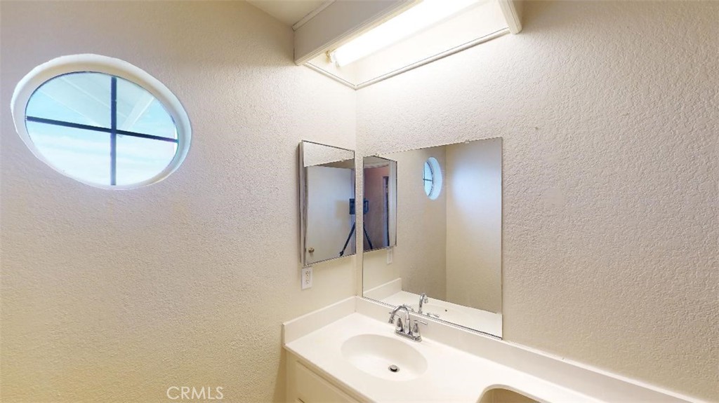 12246 Pluto Drive Victorville, CA 92392 - Photo 14 of 64 a bathroom with a sink and a mirror