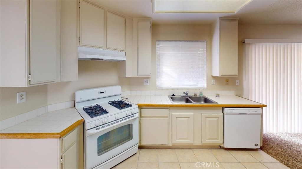 12246 Pluto Drive Victorville, CA 92392 - Photo 30 of 64 a kitchen with white cabinets and white appliances