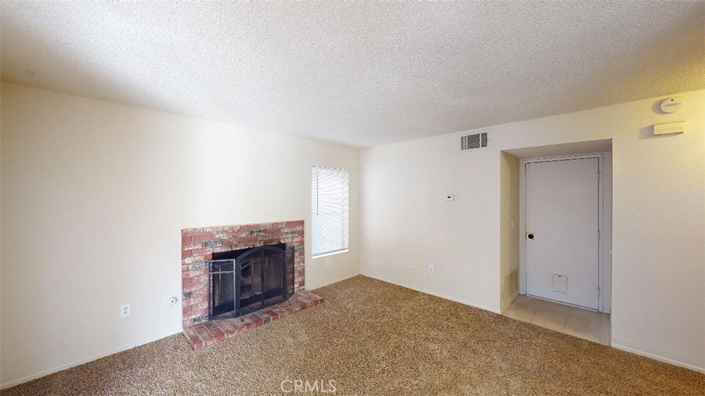 12246 Pluto Drive Victorville, CA 92392 - Photo 35 of 64 an empty room with a fireplace