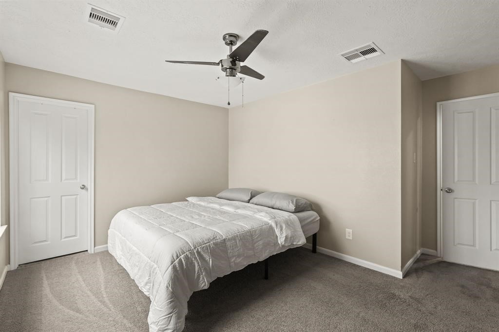 6719 Path Way Court Katy, TX 77449 - Photo 32 of 35 a bedroom with a bed and a chandelier