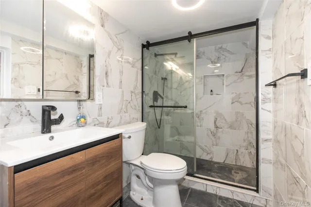 a bathroom with a sink toilet a mirror and shower