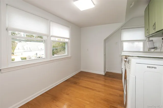 a view of empty room with window and wooden floor