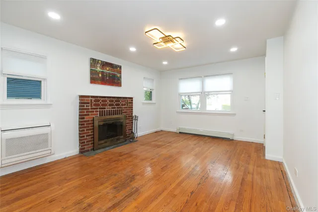 an empty room with windows and fireplace