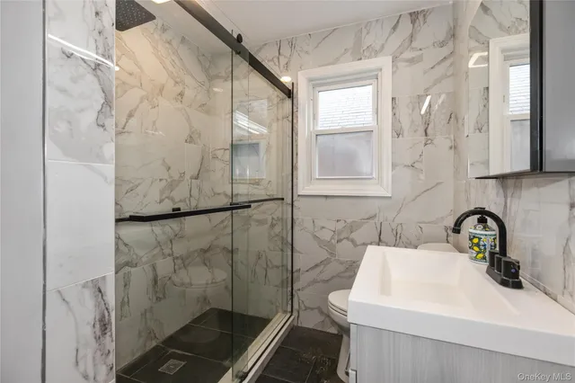 a bathroom with a sink a toilet and shower