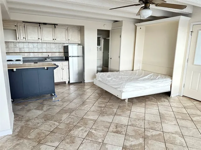 a kitchen with kitchen island granite countertop a stove a sink and a refrigerator