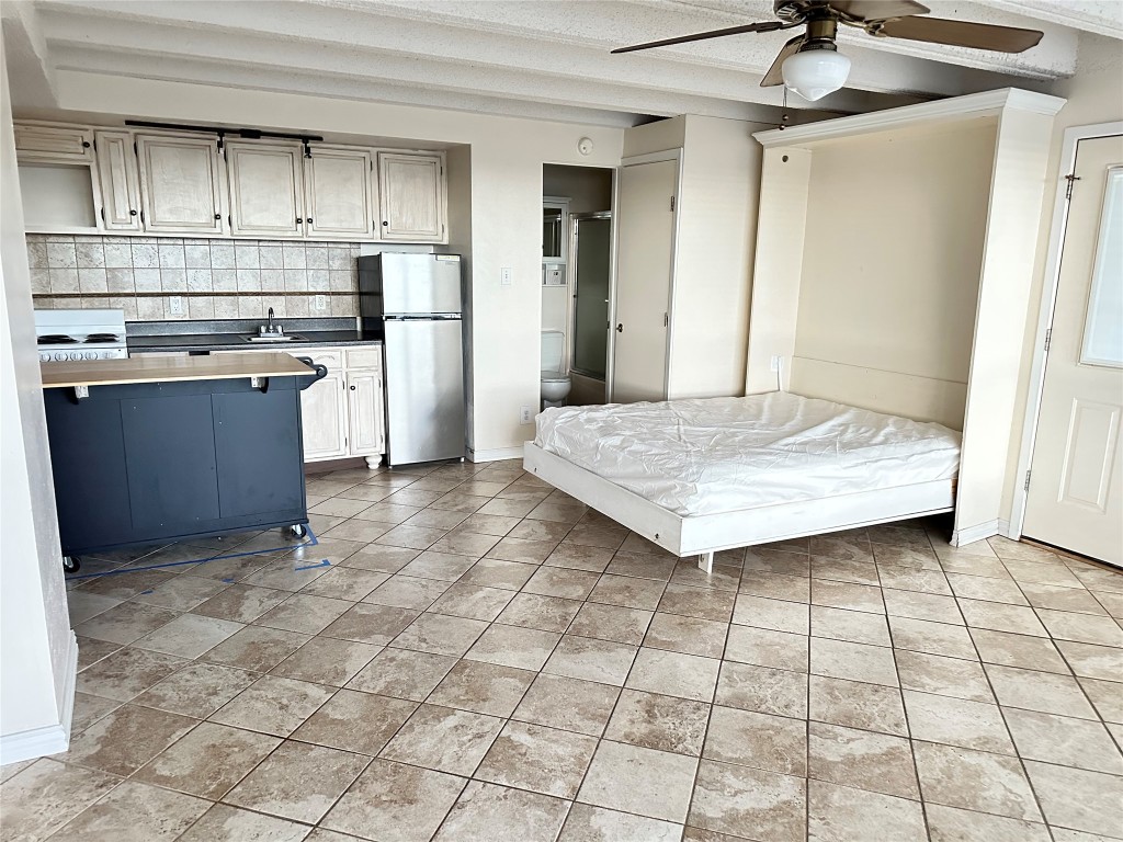 5916 Lago Vista Way, Unit B18 Lago Vista, TX 78645 - Photo 4 of 16 a kitchen with kitchen island granite countertop a stove a sink and a refrigerator