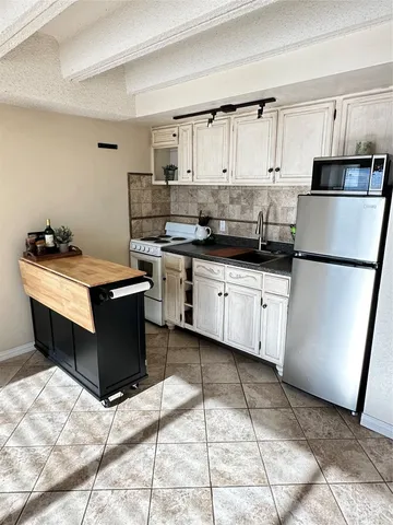 a kitchen with a sink a stove a refrigerator and cabinets