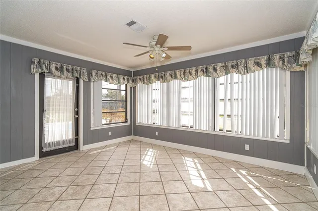 a view of an empty room and window chandelier fan