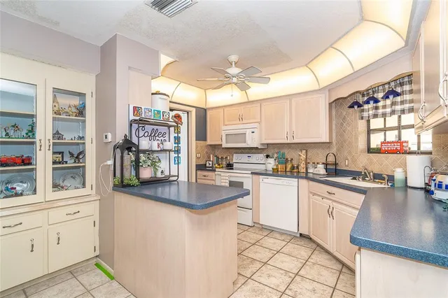 a kitchen with white cabinets and appliances