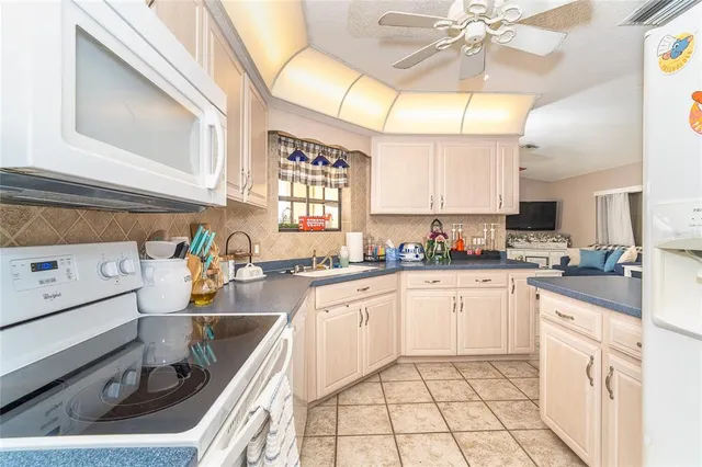 a kitchen with stainless steel appliances granite countertop a sink a stove cabinets counter space and a window