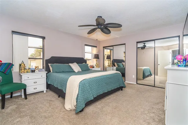 a bedroom with a bed chandelier and a window