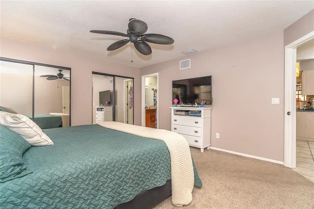 a spacious bedroom with a bed and a flat screen tv