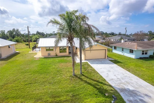 a front view of a house with garden and trees