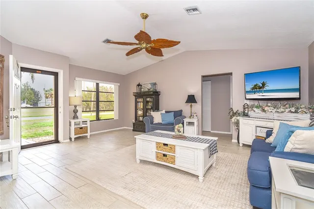 a living room with furniture a flat screen tv and a floor to ceiling window