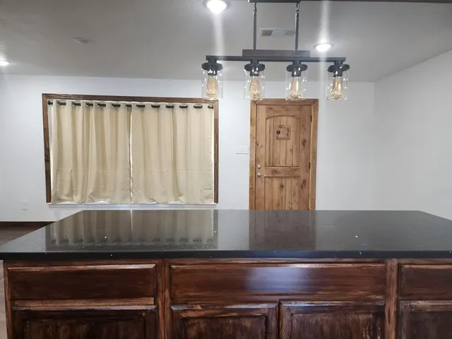 a view of a kitchen with furniture and wooden floor