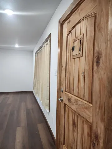 a view of a hallway with wooden floor and staircase